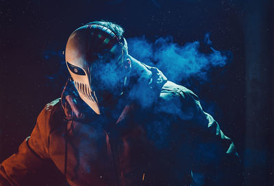 Digital composite image of person wearing mask against black background