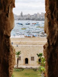 View of boats moored in sea by cityscape