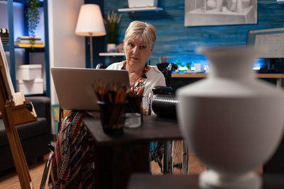 Portrait of woman using smart phone on table