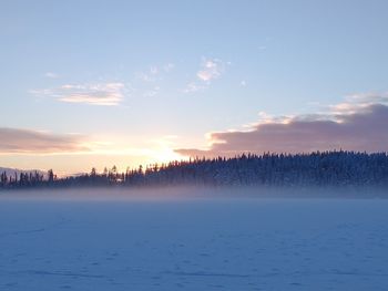 Scenic view of frozen lake against sky during sunset