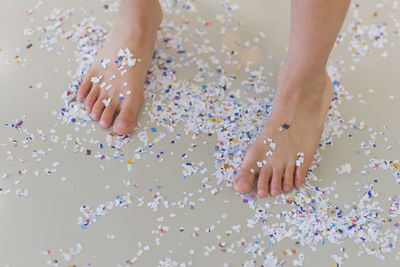Low section of person standing on confetti