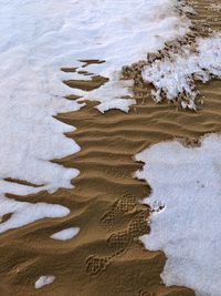 High angle view of footprints on sand at beach