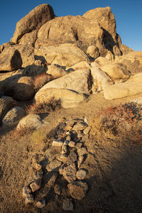Rock formations on desert land with stone cross on grave