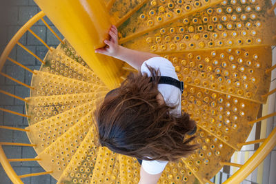 Rear view of woman walking on staircase