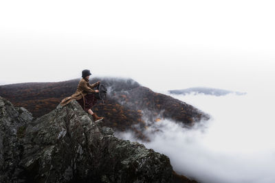 Man on horse by mountain against clear sky