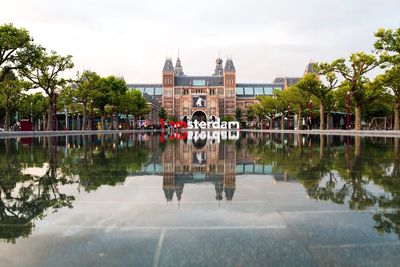 Rijksmuseum with text reflection in lake against sky