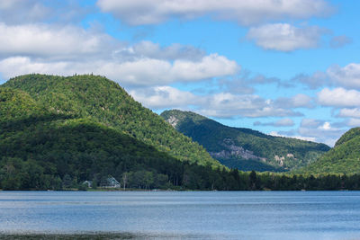 Scenic view of river by mountains against sky