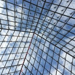 Low angle view of glass building against sky