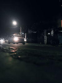 Cars on illuminated street at night