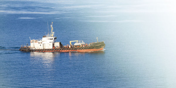 Tug the ship on a sunny autumn day on the blue sea in soft sunlight