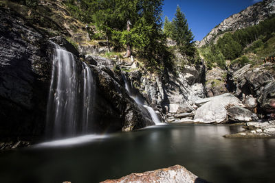 Scenic view of waterfall against sky