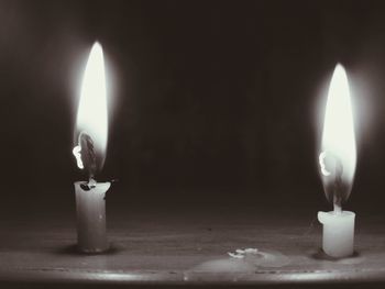 Close-up of lit candle in dark room