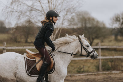 View of girl horseback riding