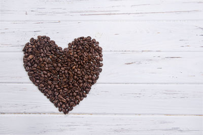 Close-up of heart shaped roasted coffee beans on table