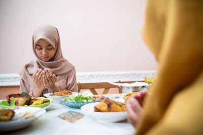 Girl in hijab praying at home