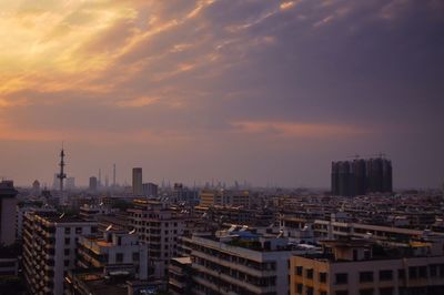 High angle view of buildings against cloudy sky during sunset