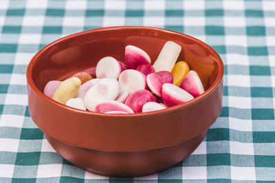 High angle view of multi colored candies in bowl on table