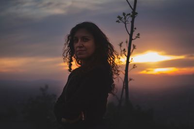 Portrait of woman standing against orange sky