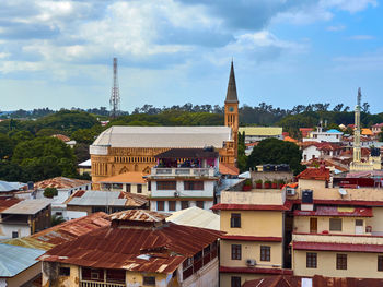 View from the balcony to the red roof and clock tower of historical stone town, zanzibar, tanzania.