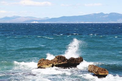 Scenic view of a wave on rocks 