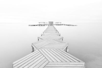 Pier over lake against sky