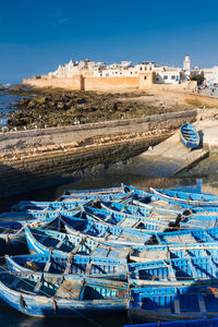 Boats moored at harbor against buildings in city