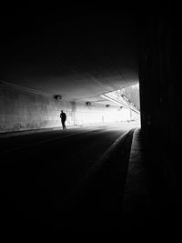 Silhouette man walking in tunnel