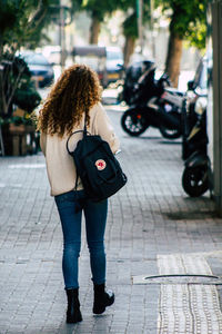 Rear view of woman standing on footpath