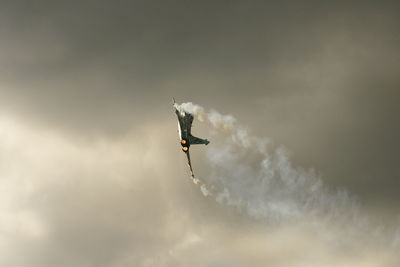 Low angle view of fighter plane flying against sky