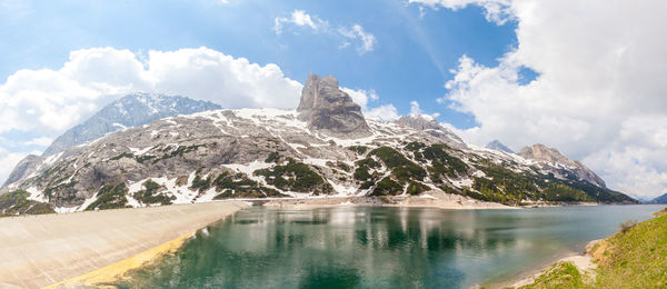 Scenic view of lake by mountain against sky