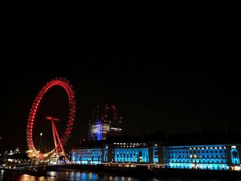 Illuminated ferris wheel at night