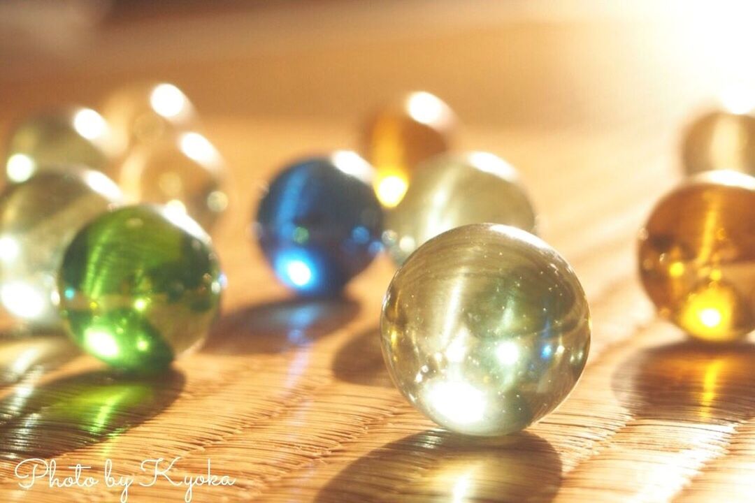 indoors, illuminated, decoration, focus on foreground, table, close-up, lens flare, lighting equipment, celebration, glass - material, selective focus, defocused, still life, shiny, reflection, glowing, christmas, no people, pattern, in a row