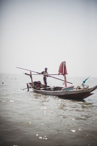 Boat sailing in sea against clear sky