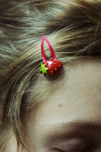 Cropped image of woman wearing strawberry hair pin