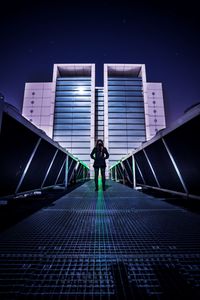 Man standing on umbrella against sky