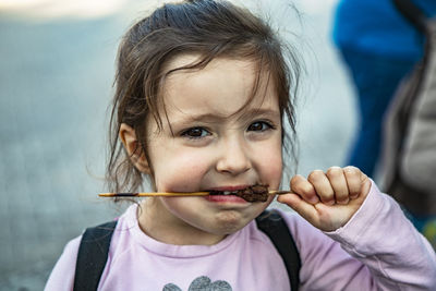 Close-up portrait of cute girl eating food