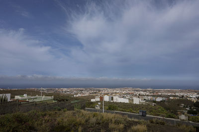 High angle view of townscape by sea against sky