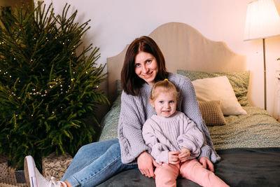 Portrait of young woman sitting on sofa at home