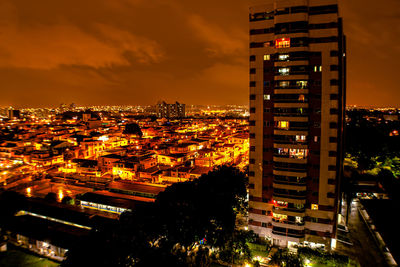 High angle view of illuminated buildings against sky at night