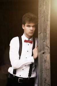 Portrait of young man standing on wood