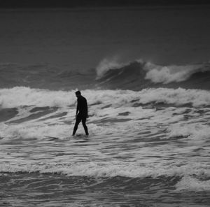 Silhouette man with surfboard at beach