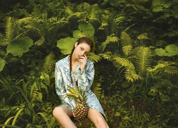 Happy young woman against plants