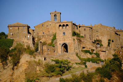 Low angle view of old building against clear blue sky