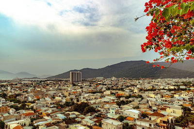 Aerial view of townscape and mountains against sky