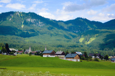 Scenic view of green landscape and mountains against sky