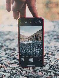 Midsection of person photographing with mobile phone