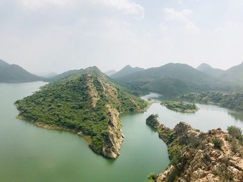 High angle view of lake and mountains against sky