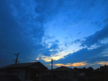 Low angle view of houses against sky at sunset