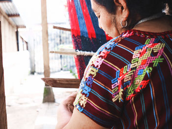Midsection of woman with multi colored umbrella