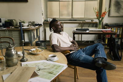 Businessman with eyes closed relaxing on chair in home office